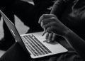 grayscale photo of person using MacBook